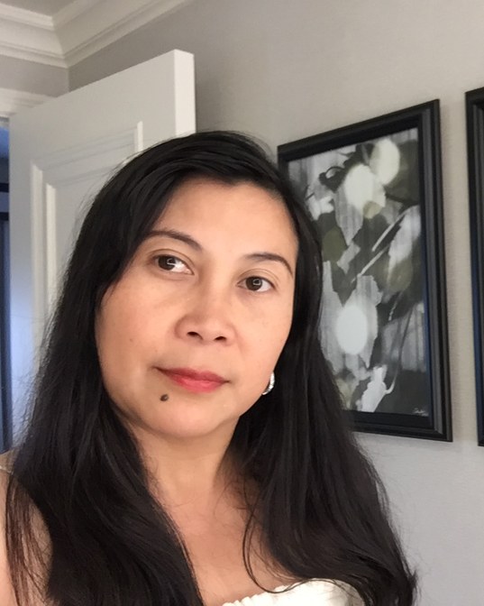 Joriza Apuada beside two framed prints